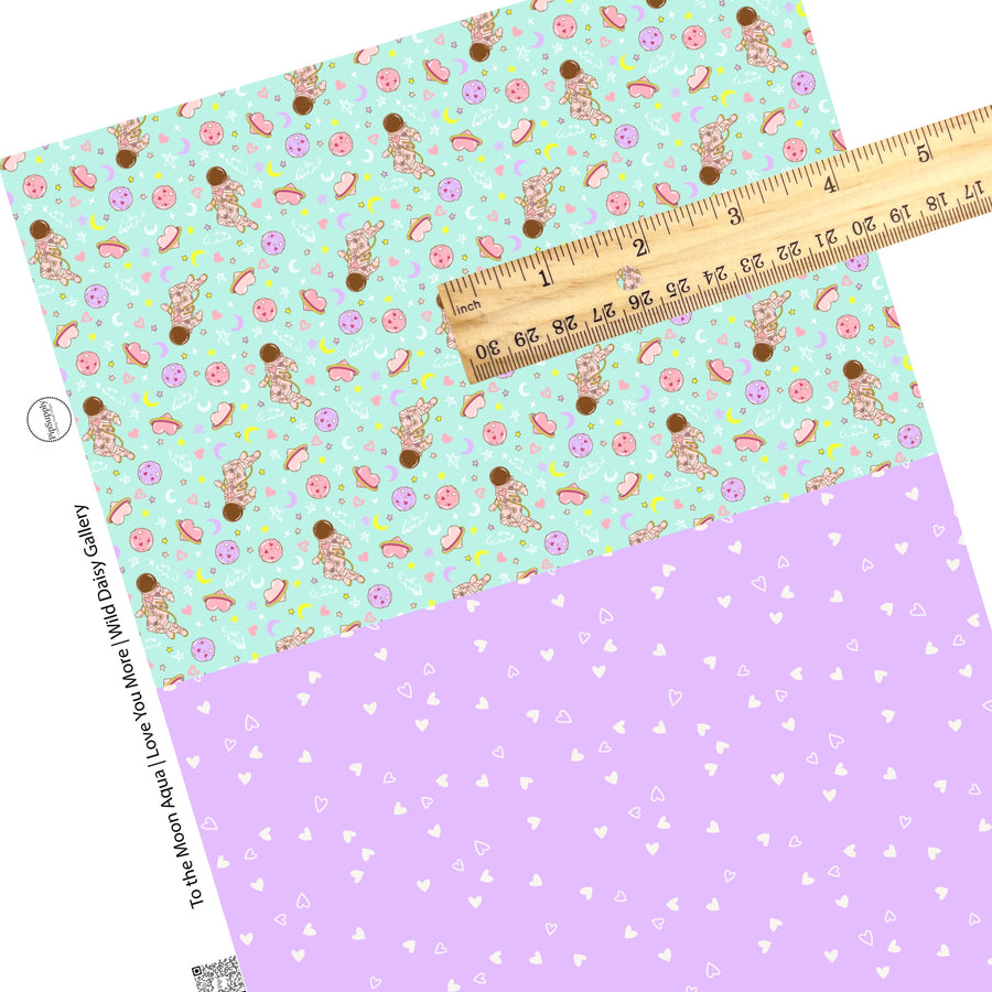 Pink planet with purple and pink moons with pink astronaut and white hearts on lavender faux leather sheet