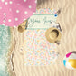 Pastel Malibu Floral print custom beach towel laid out on the shore.