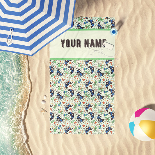 Hang Loose jeep and palm tree print beach towel laid out by the shore.