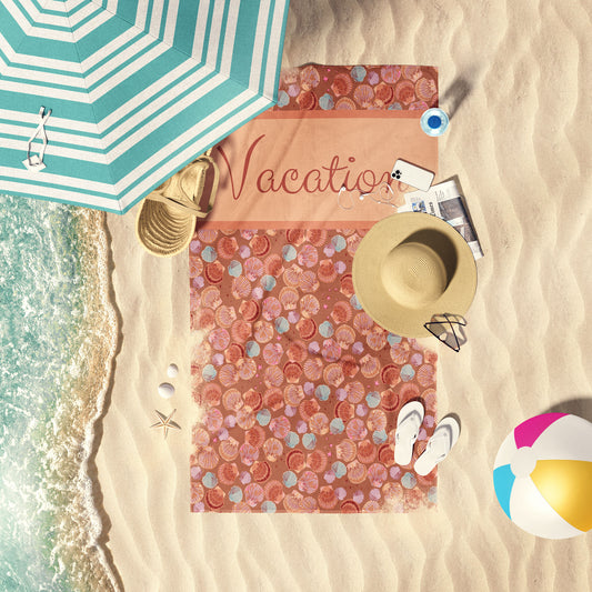 Vintage Seashells on copper print beach towel laid out by the water at the beach.