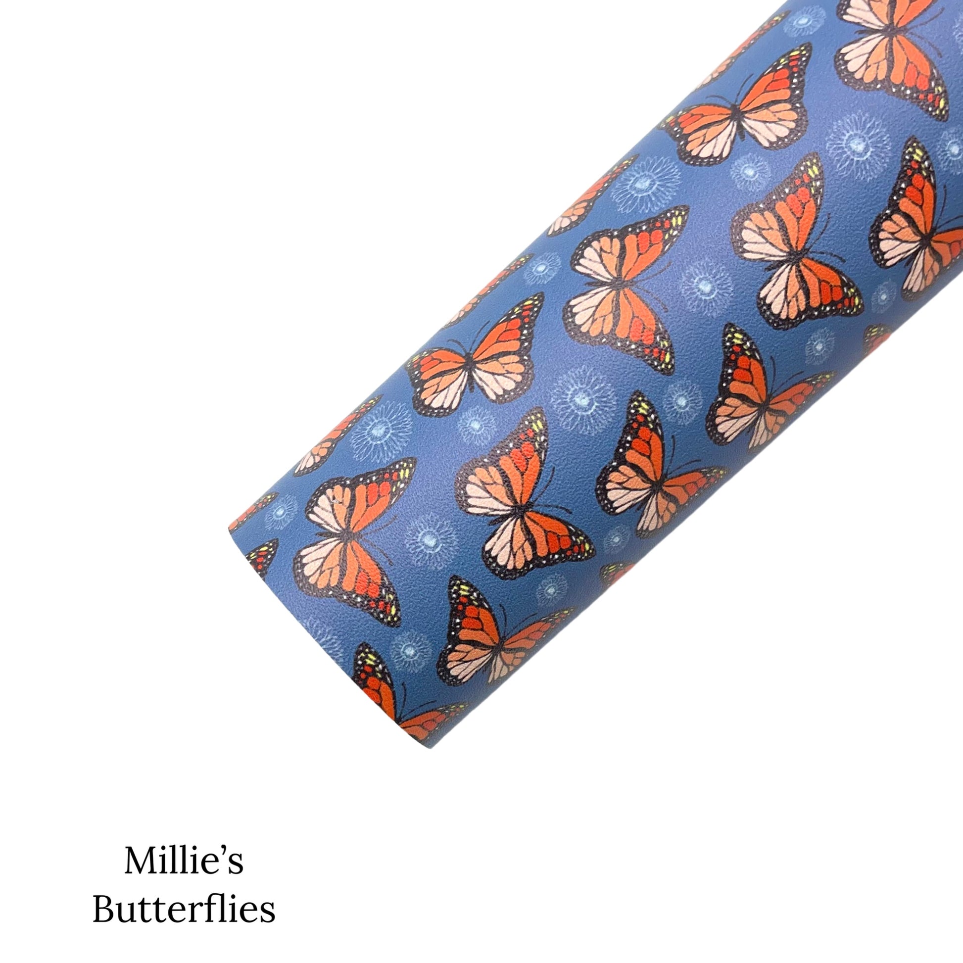 Rolled blue faux leather sheet with orange and black monarch butterflies and white flower pattern.
