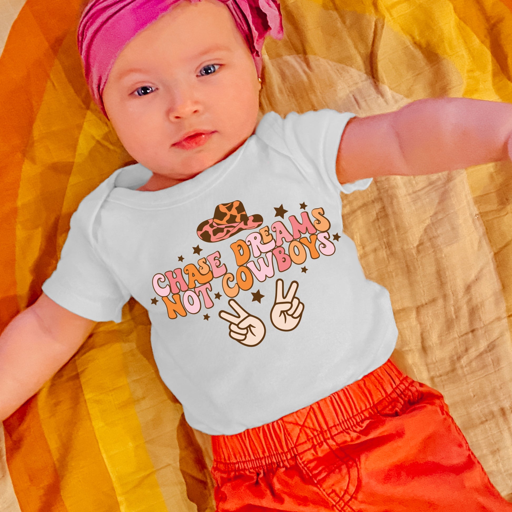 Pink and Orange "Chase Dreams, Not Cowboys" Iron on heat transfer with a cow print cowgirl hat and brown stars.