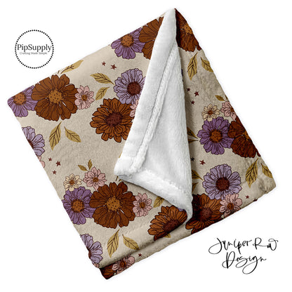 Soft folded minky fur blanket in cream, brown, and purple floral pattern.