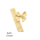 Small sized cream colored bow with frayed dots on a white background