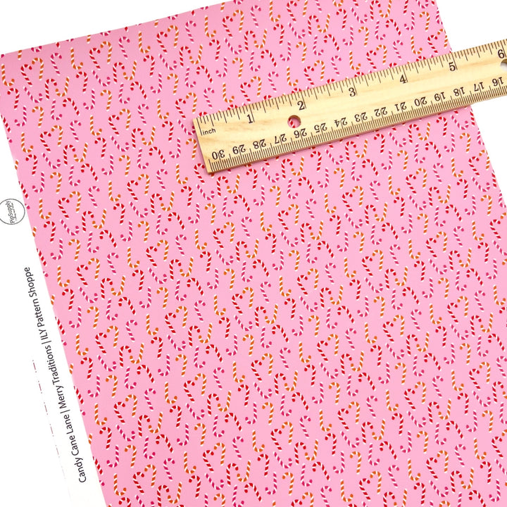 Rolled or individual christmas faux leather sheet with red and white candy canes on pink background