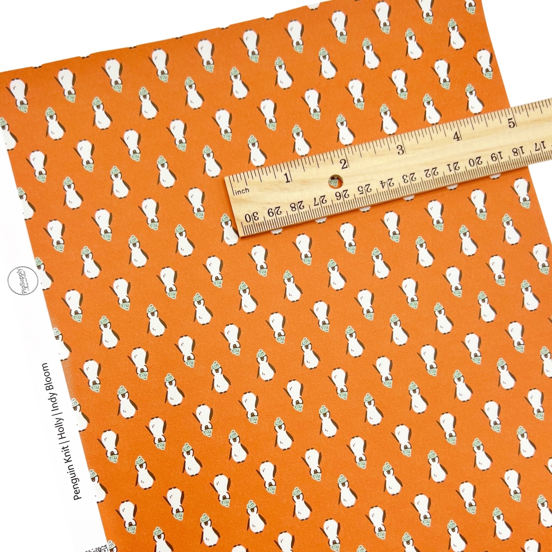 Rolled or individual christmas faux leather sheet with penguins on an orange background