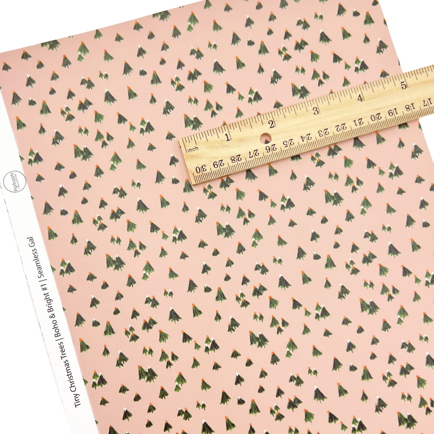 Pink Christmas faux leather sheet with tiny green Christmas tree pattern.