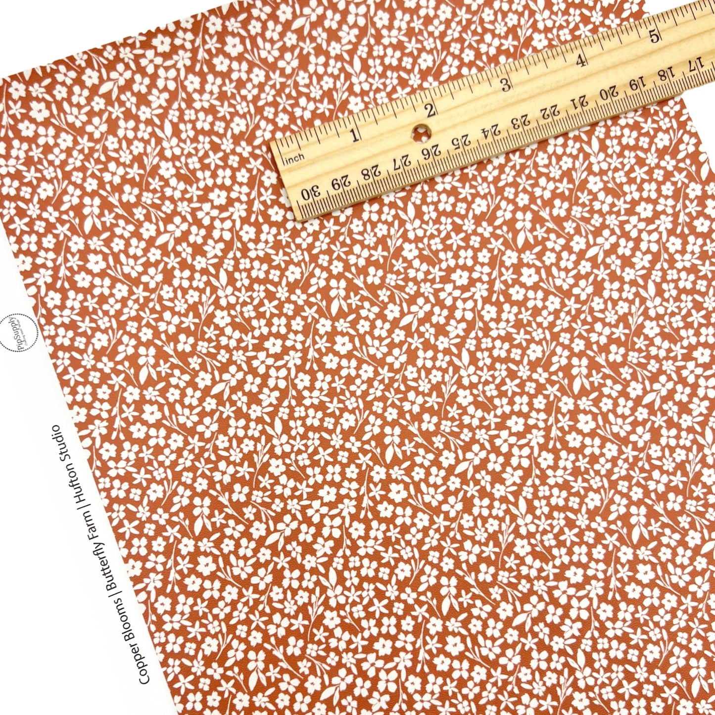 Copper colored faux leather sheet with white flowers 