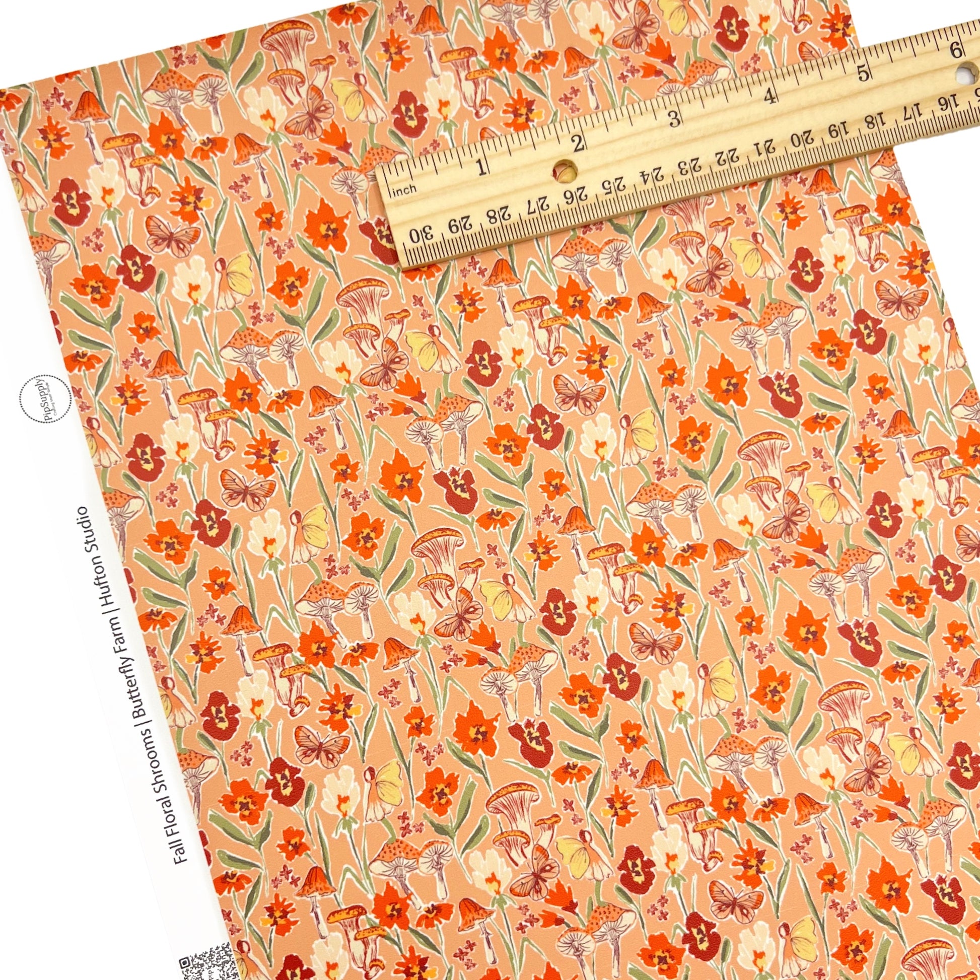 Orange colored faux leather sheets with multi colored flowers, butterflies,a nd mushrooms