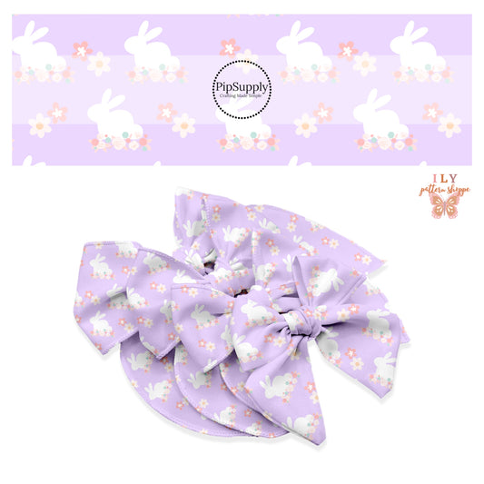 White bunnies sitting on cream and pink flowers on lavender bow strips
