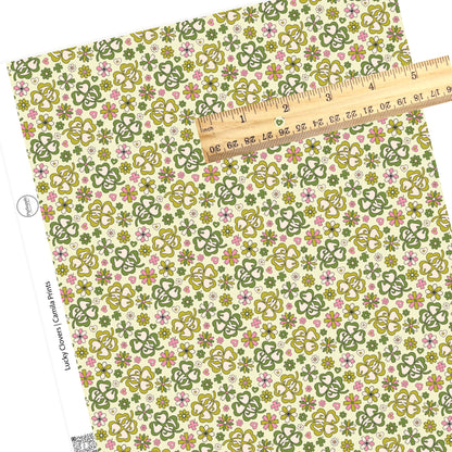 Pink tiny clovers with big green clover with "lucky" and pink and green flowers on a light green faux leather sheet