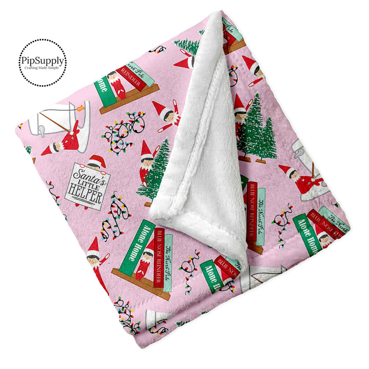 Pink Christmas elf on a shelf on pink folded minky furry blanket. Custom Printed Elf Blanket.