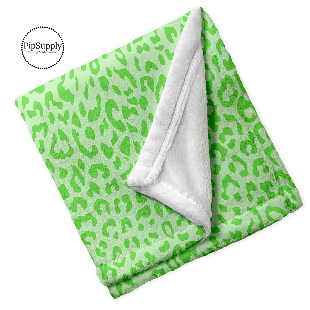 Soft folded minky blanket with light green and lime green leopard animal print.