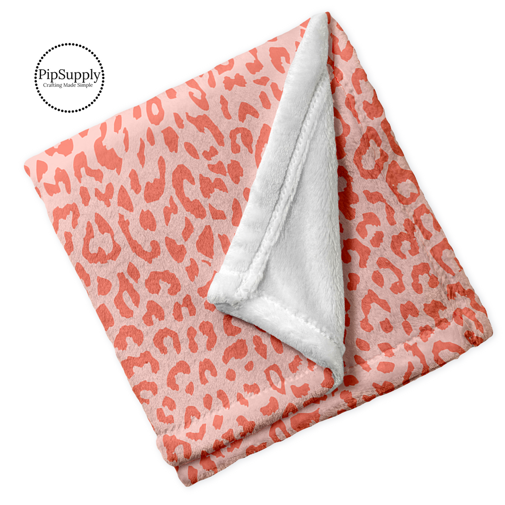 Soft folded minky blanket with peachy orange leopard animal print.