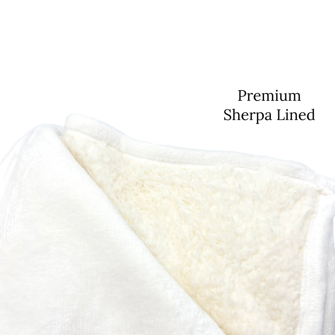 Folded thick fuzzy blanket with inner bottom lining of thick Sherpa furr in base white color.