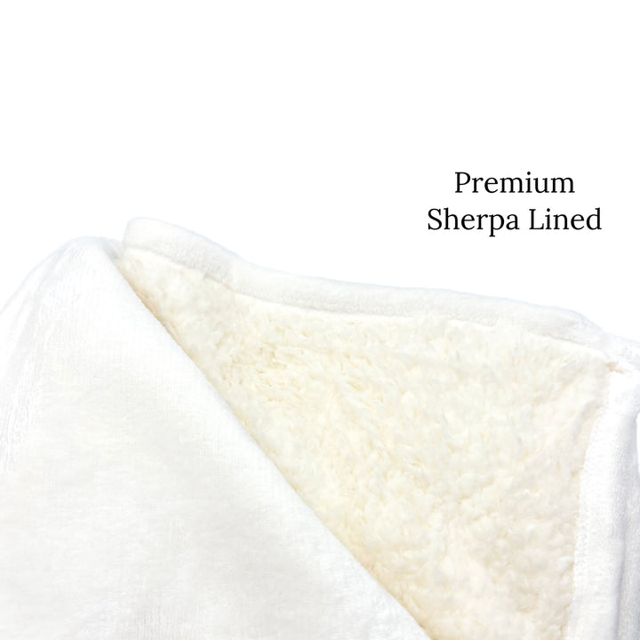 Folded thick fuzzy blanket with inner bottom lining of thick Sherpa furr in base white color.