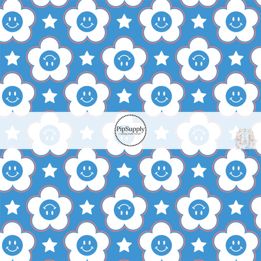 Red, white, and blue smiley face daisies and stars on blue fabric by the yard