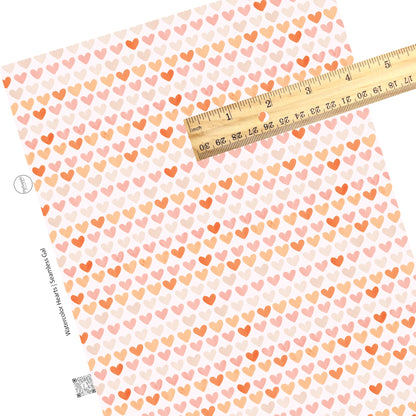 Pink and orange watercolor hearts in a line on a white faux leather sheet