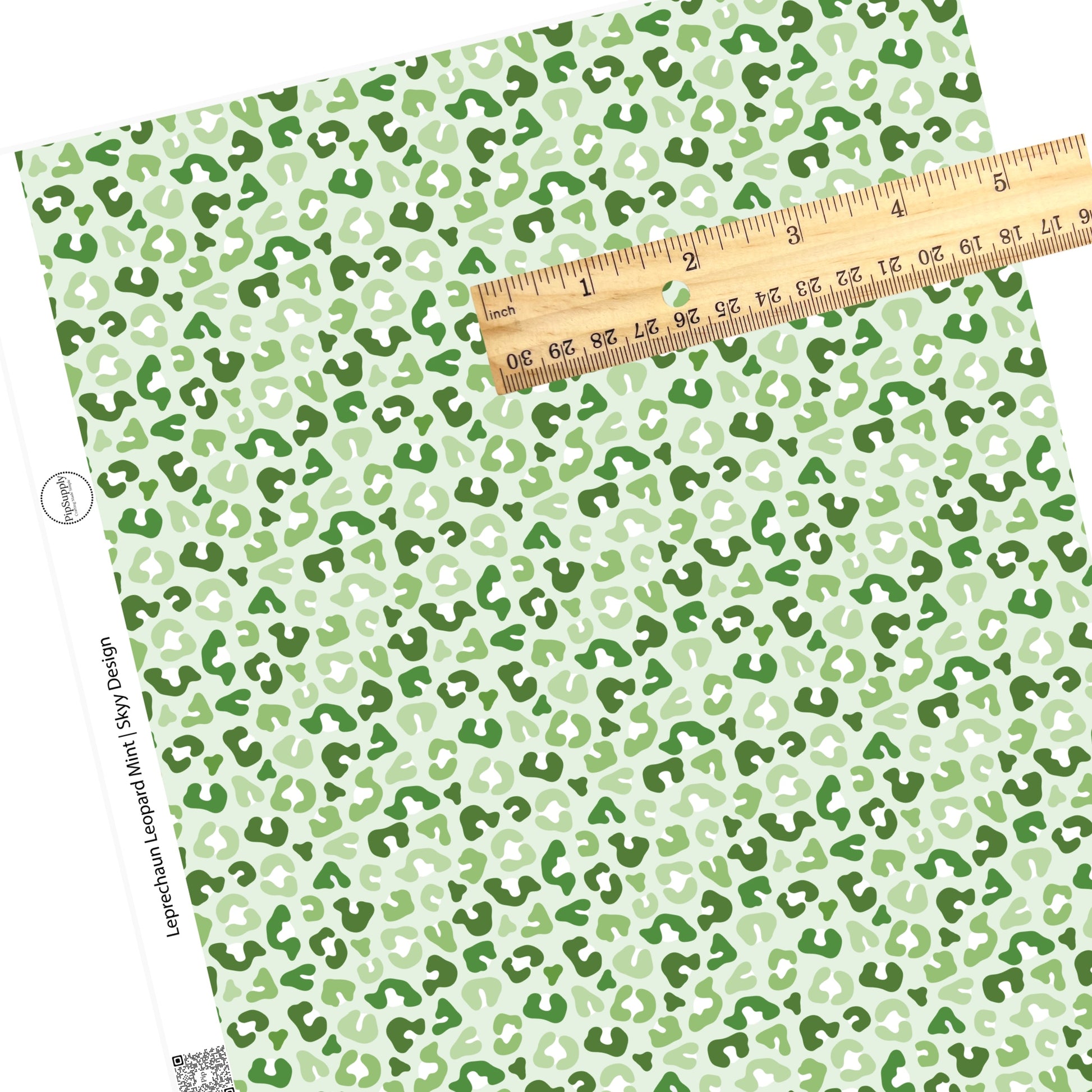 Different colors of green leopard spots on a light green faux leather sheet