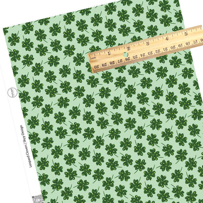 Green clovers with green leopard print on a light green faux leather sheet