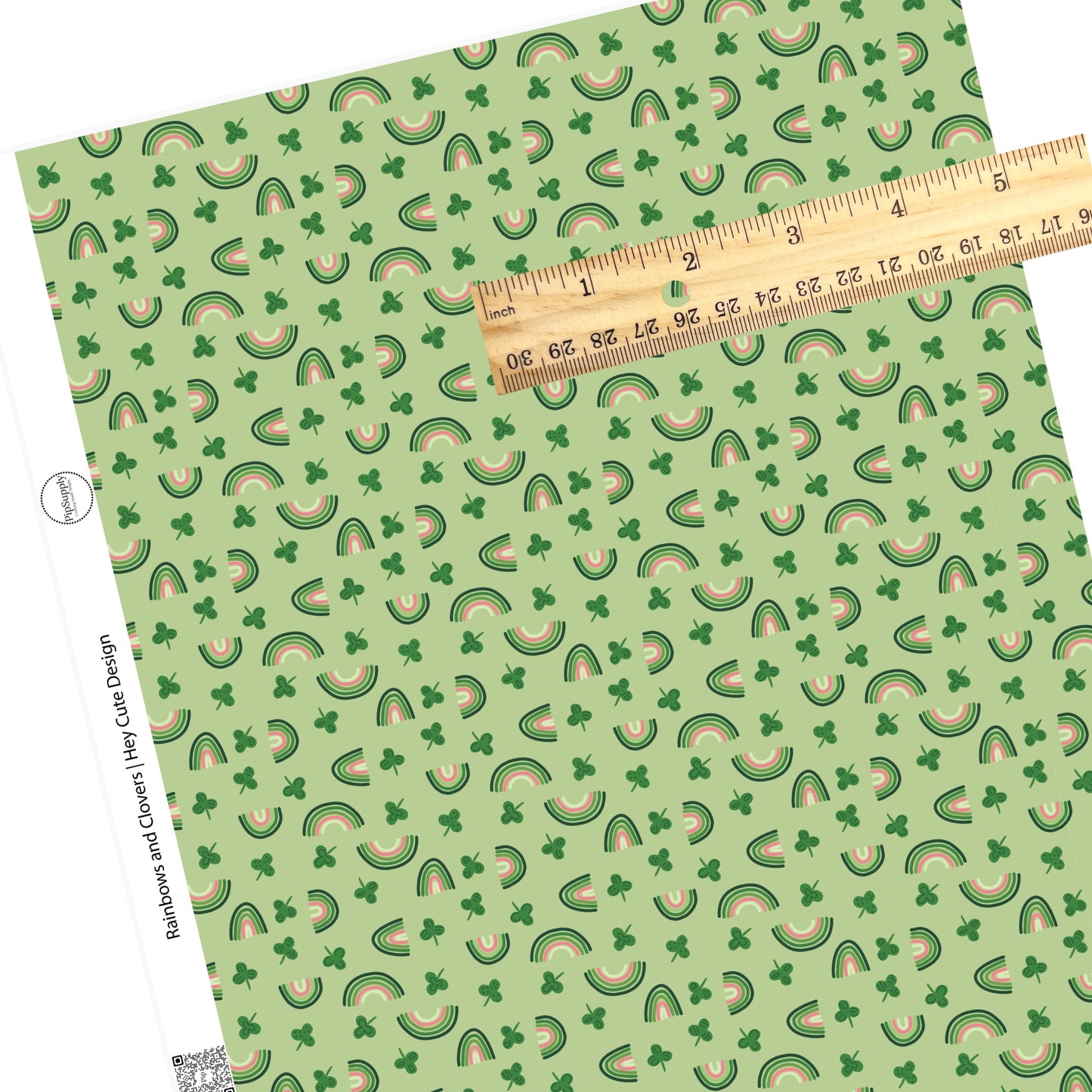 Disperse polka dot clovers with pink and different shades of green rainbows on a green faux leather sheet