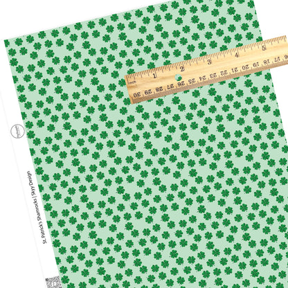 Scattered green shamrocks on a green faux leather sheet