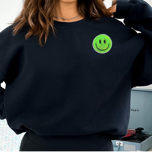 Neon green sequined smiley face iron on patch on a black sweatshirt
