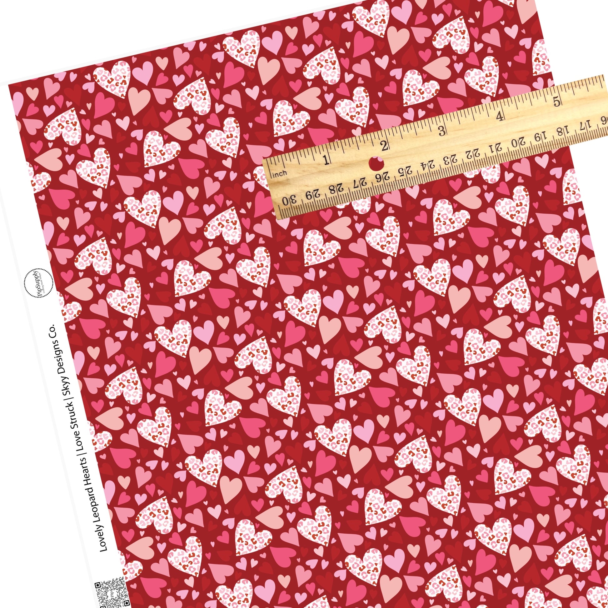 White leopard hearts and tiny multicolored hearts on red faux leather sheets