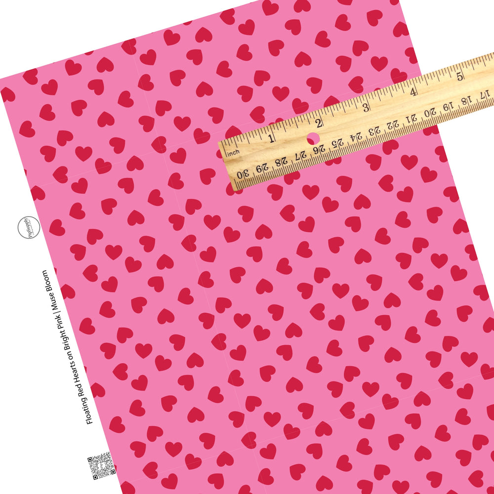 Disperse red hearts on a dark pink faux leather sheet