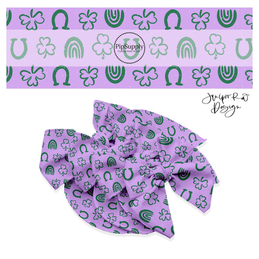 Clovers, rainbows, and horseshoes with white polka dots on a purple bow strip