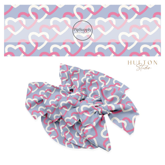 Repeating white and hot pink hearts connected on a blue bow strip