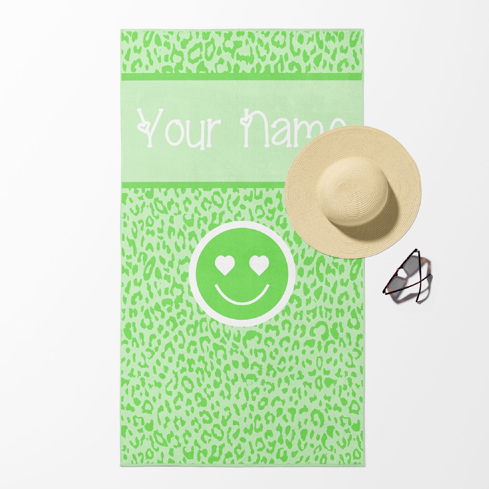 Beach towel in lime green leopard print with smiley face and customizable text.