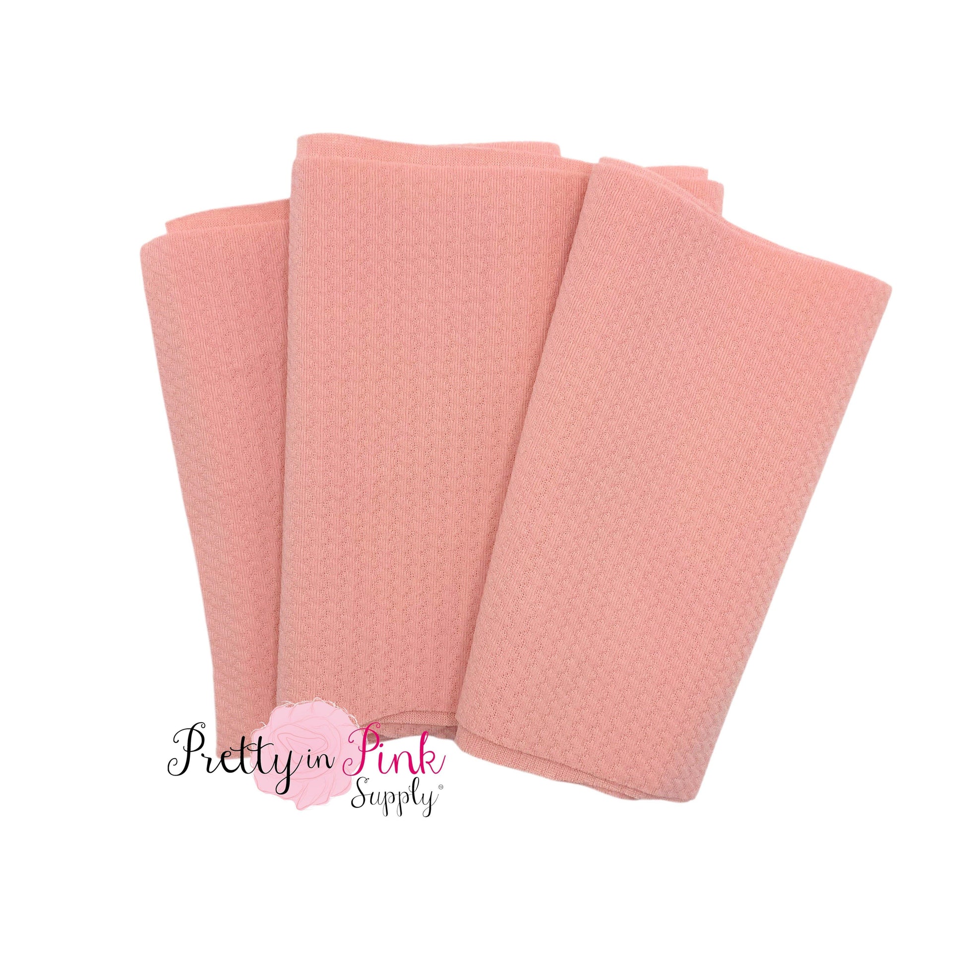 Folded over solid pastel peach color textured, stretch liverpool fabric strip.