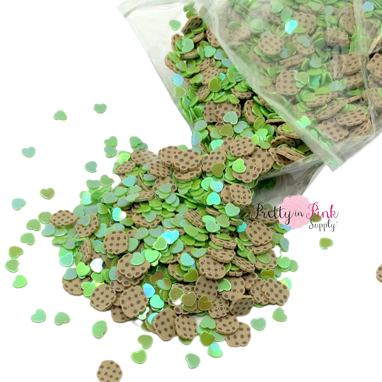 Spilling bag of green heart confetti glitter mixed with cookie clay slices.