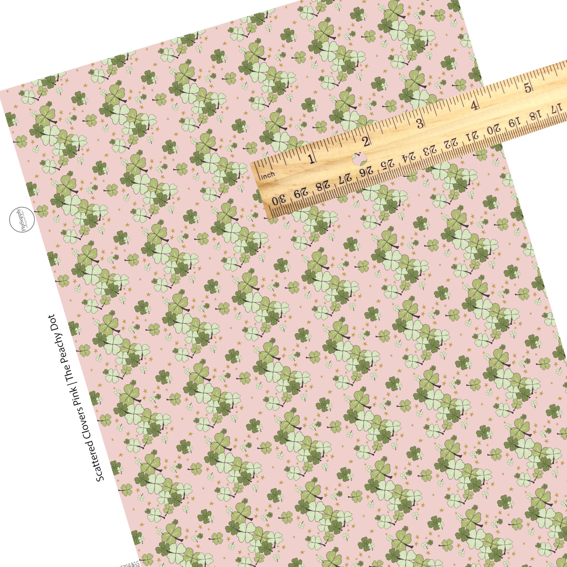 Scattered green and light green clovers on a light pink faux leather sheet