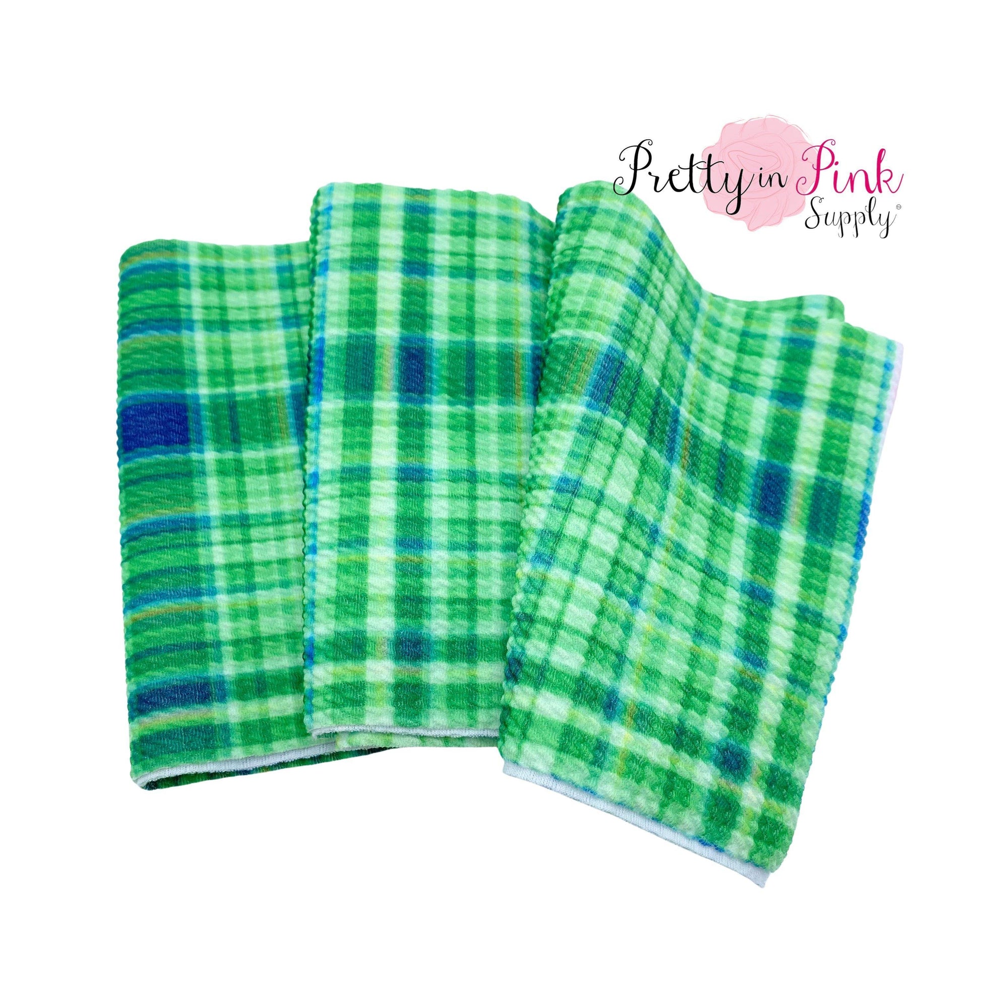 Folded liverpool fabric strip with green and blue plaid pattern.
