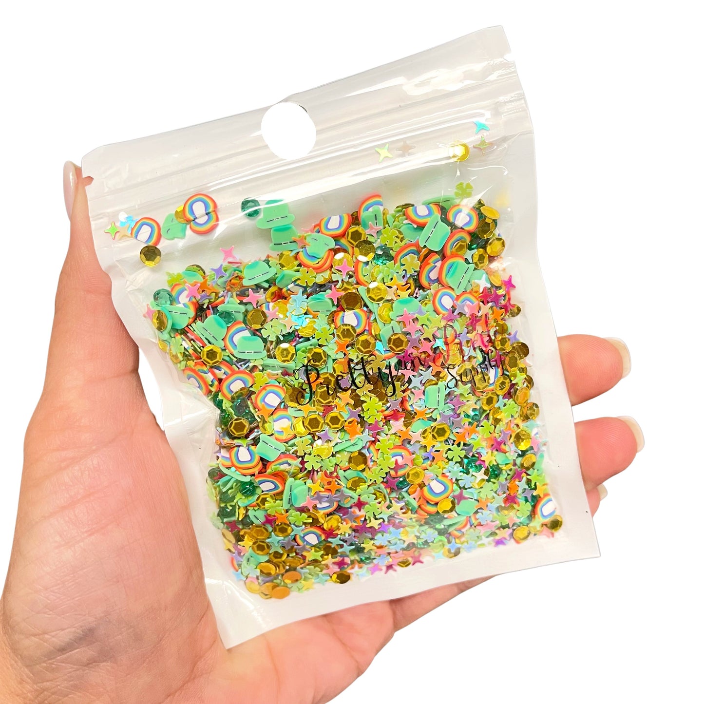 Resealable bag of St. Patrick's Day clay and sequin mix including rainbow clay slices, green shamrock clay slices, aqua gems, gold coins sequin glitter, and pastel rainbow sequin glitter.