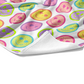Plush white cotton towel with blue, peach, purple, green, and yellow leopard print smiley faces pattern on the front.
