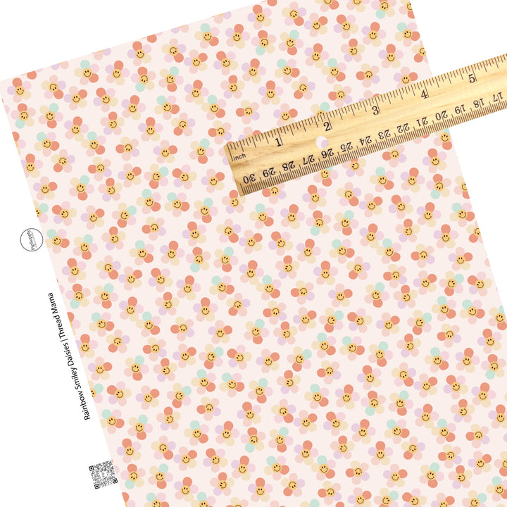 Scattered daisies with rainbow petals and smiley face on a pink faux leather sheet