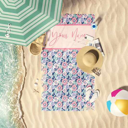 Butterfly bloom print beach personalized towel laid out by the water on the sand.