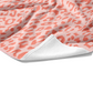 Plush white cotton towel with peach and pale peach leopard animal print on the front.