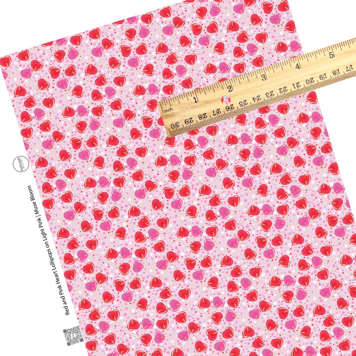 White and pink stars with red hearts and scattered red and pink heart suckers on a pink faux leather sheet