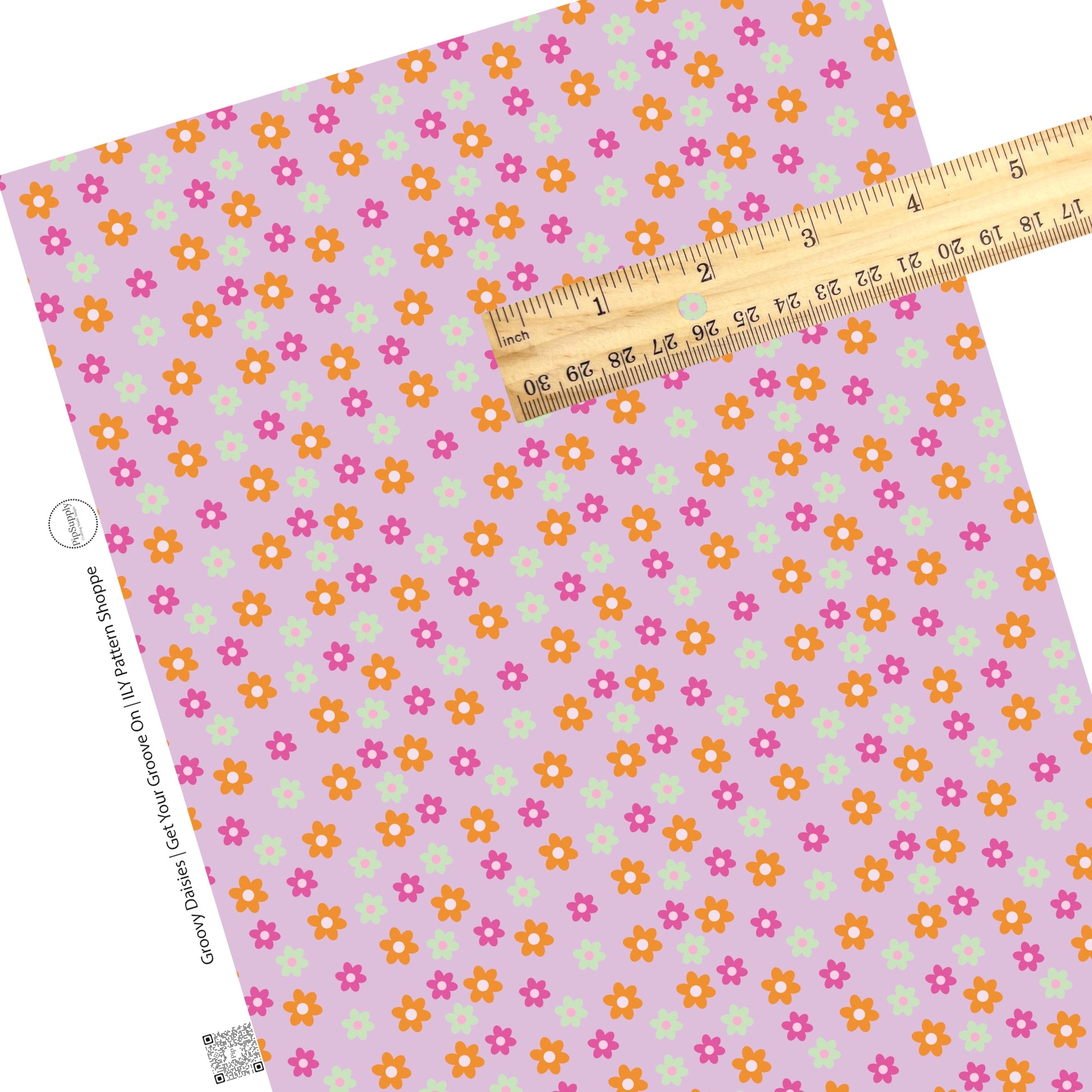 Pink, orange, and mint flowers with different shades of pink centers on a lavender faux leather sheet