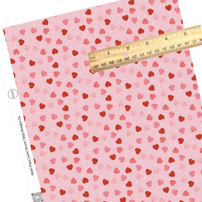 Red scattered candy hearts with pink background faux leather sheets