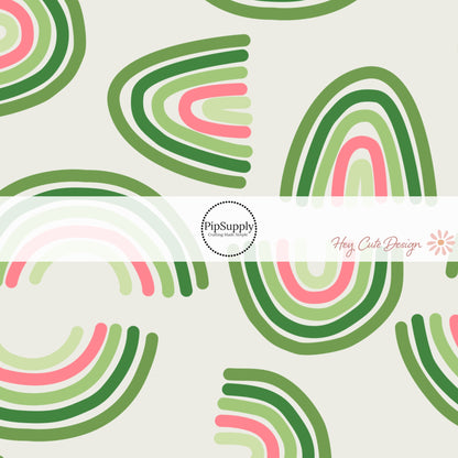 Different shades of green lines and pink accents in a rainbow on a light green/cream bow strip