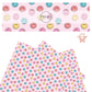 Coral, blue, pink, and yellow smiley faces on a light pink faux leather sheet