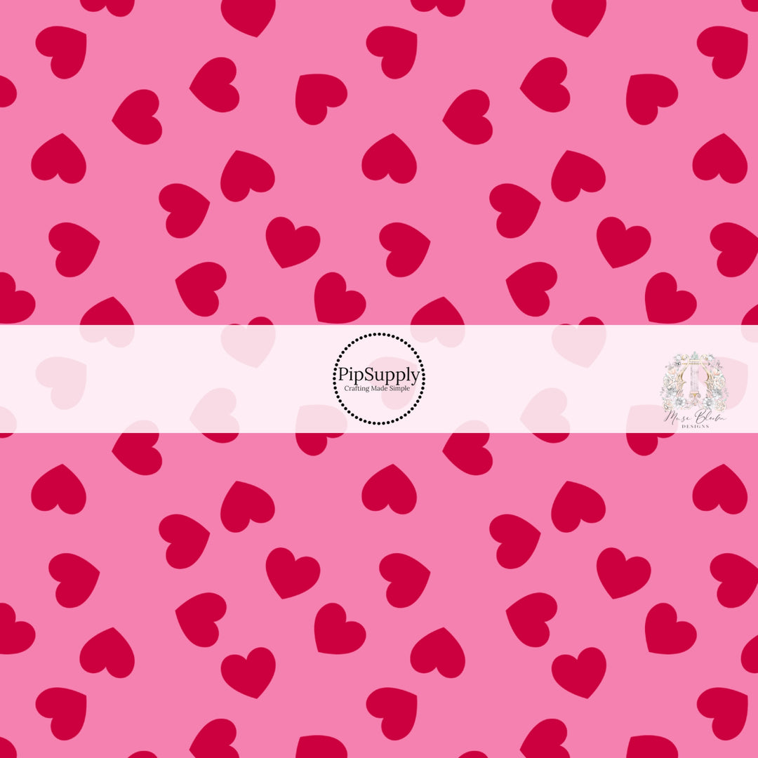 Pink fabric by the yard with red scattered hearts pattern