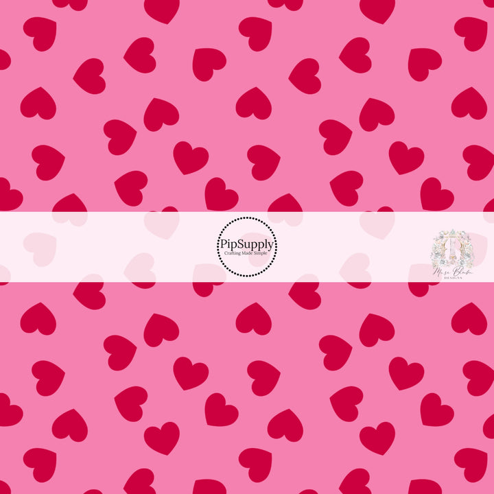 Pink fabric by the yard with red scattered hearts pattern