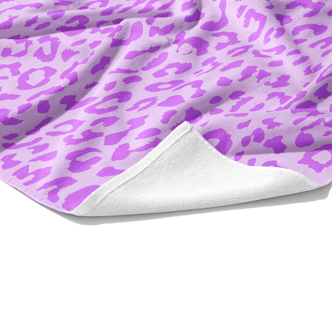 Plush white cotton towel with lavender and purple leopard animal print on the front.