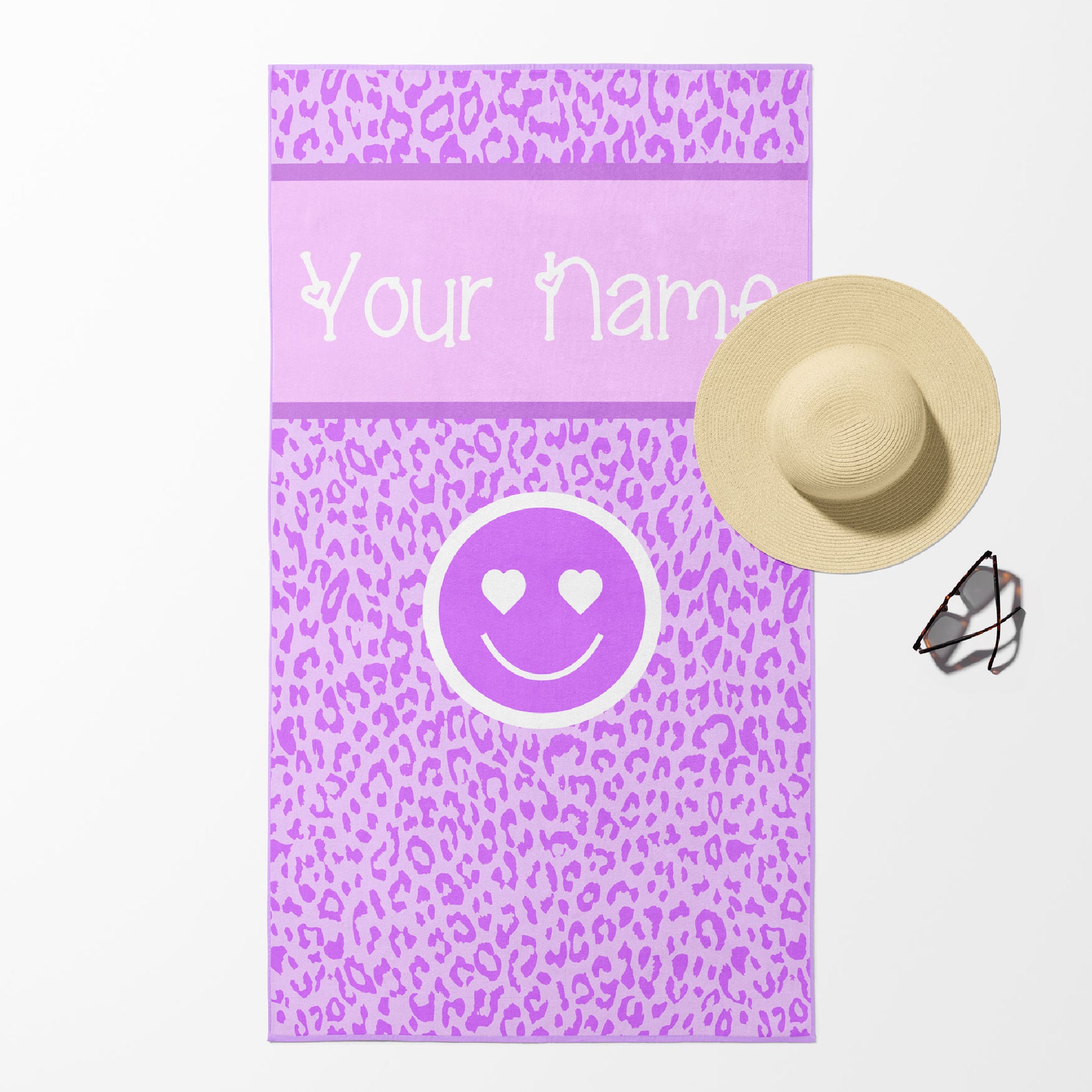 Beach towel in purple and lavender leopard print with smiley face and customizable text.